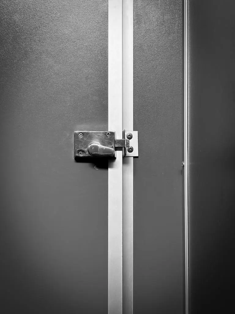 Close-up of a locked metal door with industrial design, emphasizing privacy.