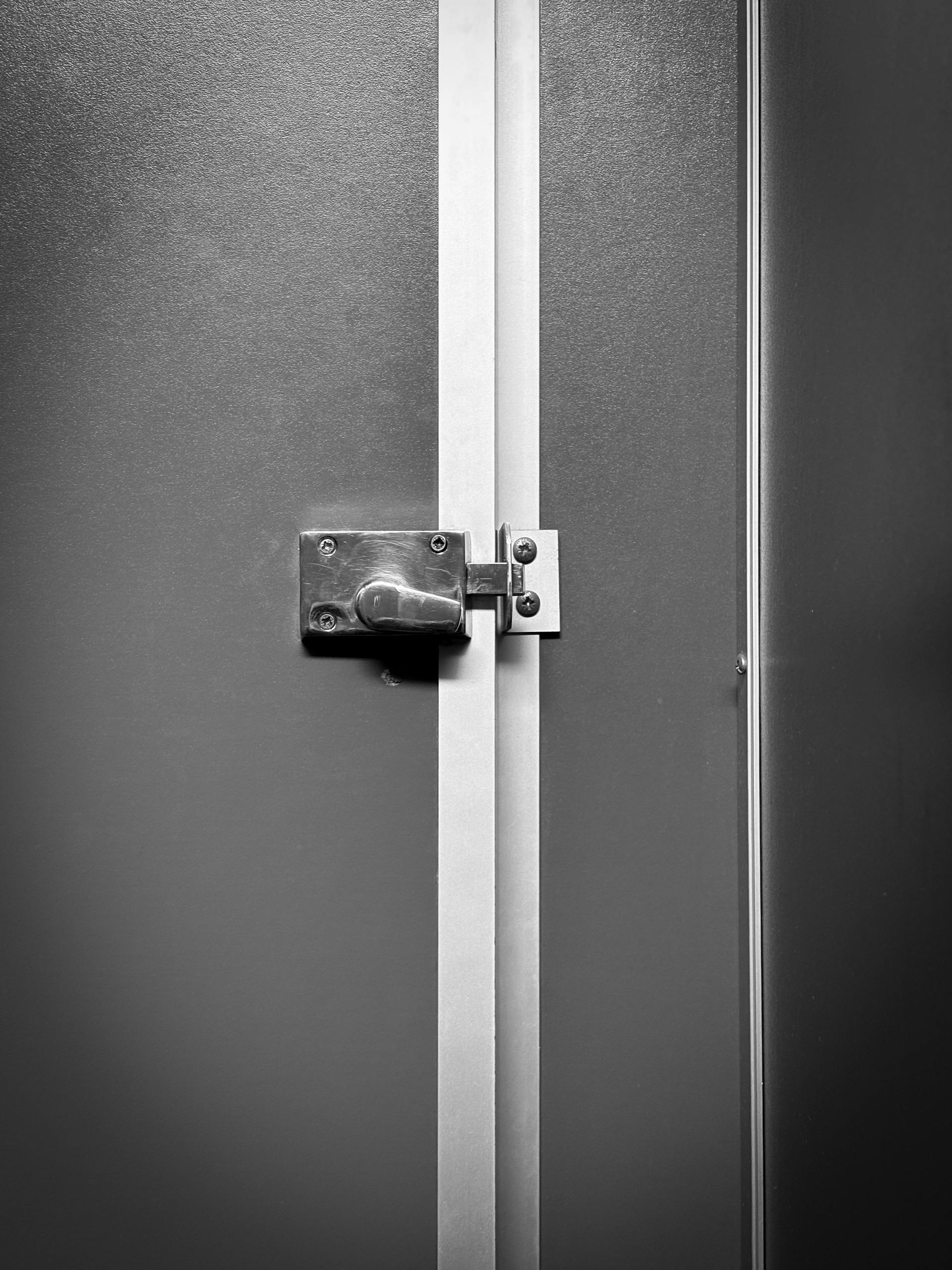 Close-up of a locked metal door with industrial design, emphasizing privacy.